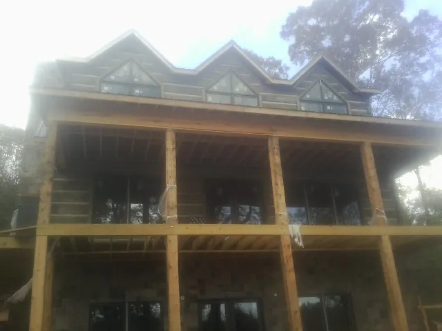 Dormers and porch framing on a large log home under construction — Roof Coating work by our crew in Grass Valley