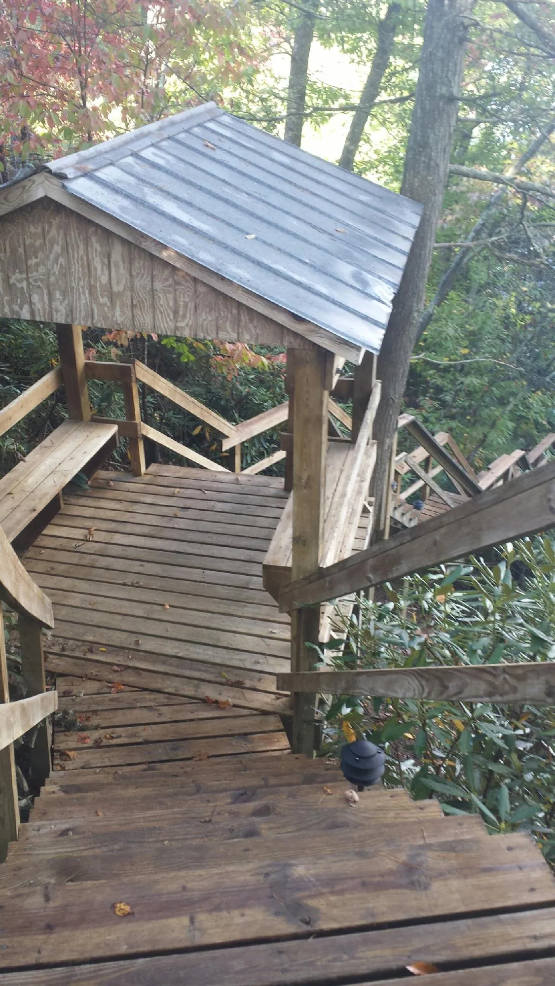 Metal roofed shelter over wooden steps on a wooded walkway — Skylight Repair & Installation work by our crew in Grass Valley